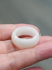 Natural Hetian white nephrite jade domed wide band ring resting on an open hand
