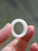 Hand holding a natural white Hetian nephrite jade domed wide band ring against natural light