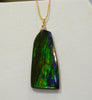 Close-up of a rare Grade AA Canadian Ammolite doublet pendant with stunning green and purple iridescent spectrum colors.
