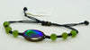 Handcrafted AA-grade ammolite bracelet laid flat, showcasing its one-of-a-kind iridescent green-blue gemstone centerpiece and adjustable black cord.