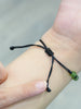 Adjustable ammolite protection and good luck talisman bracelet being worn, highlighting its comfortable fit and vibrant color shift.