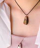 Model wearing a whole-piece Canadian Ammolite pendant necklace with 14k gold-filled settings