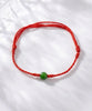 Totally hand-made Red string green jade bracelet on a white background