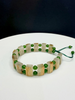 Double-strand handmade gemstone bracelet featuring square-cut gold rutilated quartz crystals and round green Polar jade beads on a white surface.