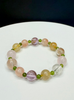 Handcrafted multi-gem crystal bracelet featuring natural Golden Rutilated Quartz, Rose Quartz, and green Canadian Polar Jade accents on a white and black background.