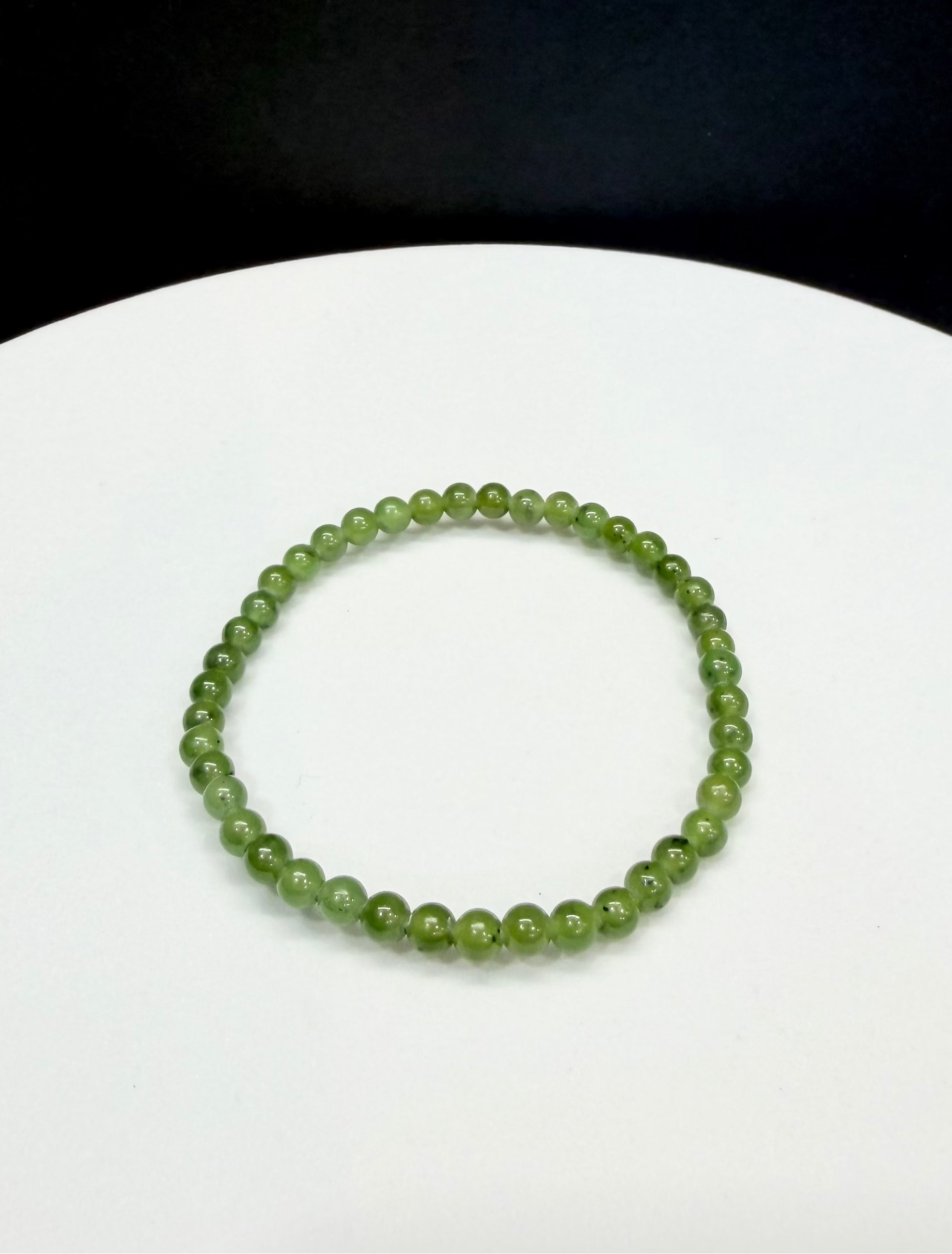 Canadian Arctic Polar jade beaded bracelet with 4mm green jade beads on a white surface with a black background.