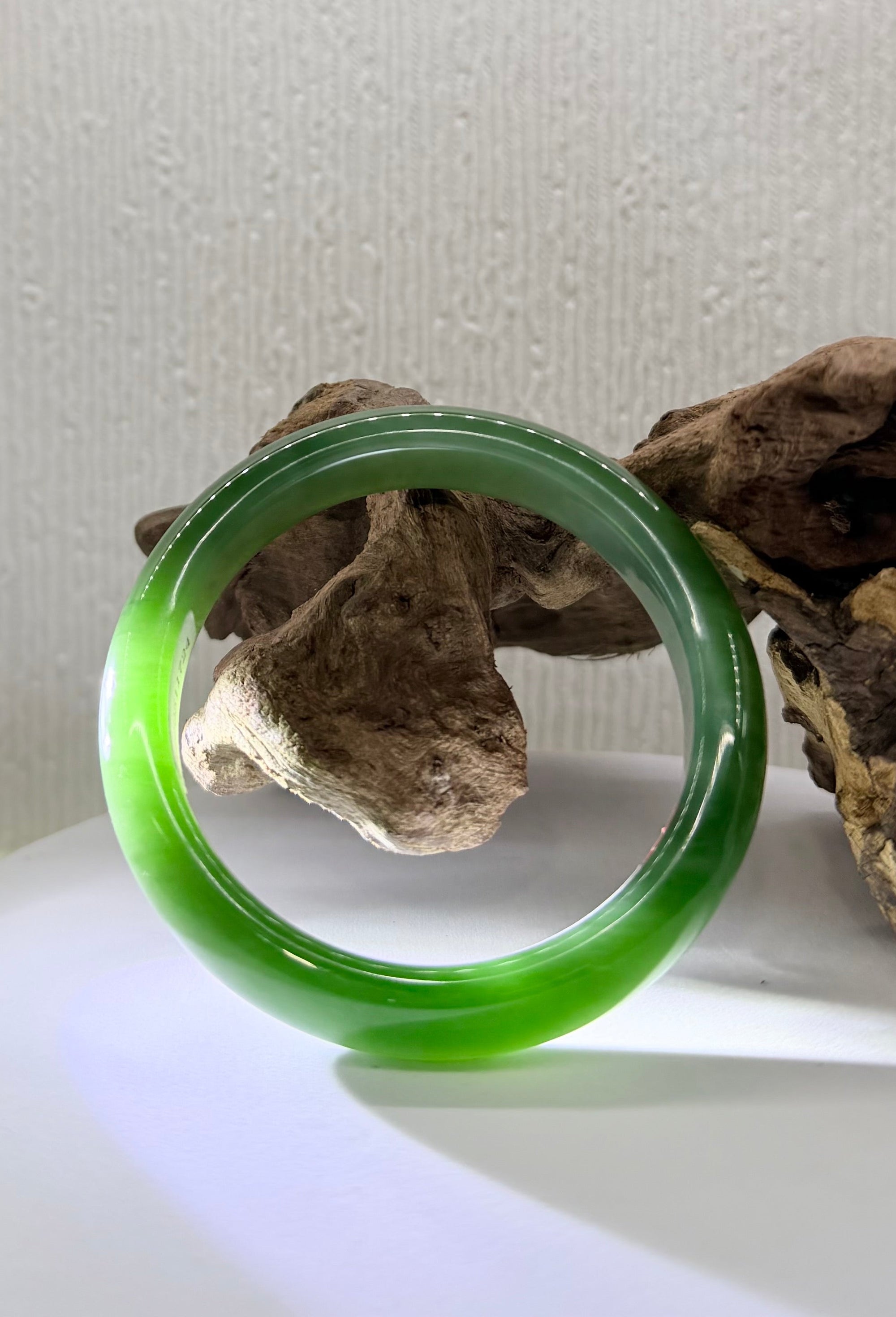 Premium 58mm Siberian flawless green chatoyant jade bangle displaying a sharp natural cat's eye line. 天然西伯利亚罕见绿猫眼碧玉手镯。